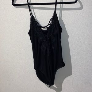 Black cami bodysuit with criss cross v-neck and lace detailing!